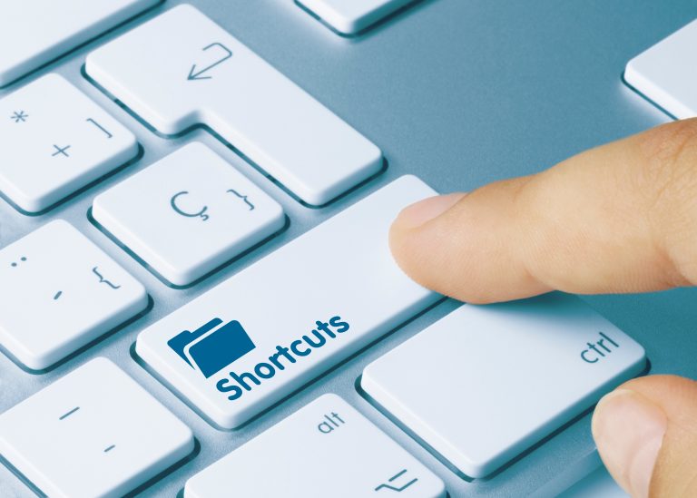 A finger touching a Shortcuts button on a keyboard.